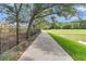 Paved walking path next to a fenced playground, pond, and green space at 103 Clarabelle Ln, Summerville, SC 29483