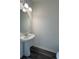 Half bathroom with a pedestal sink, round mirror, and modern light fixture at 1101 Scarlett Maple St, Summerville, SC 29486