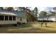 Backyard view of a house with a green metal roof and surrounding trees at 141 Wintergreen Rd, Walterboro, SC 29488