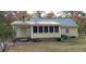 Charming single-story home with screened porch and metal roof amidst fall foliage at 141 Wintergreen Rd, Walterboro, SC 29488