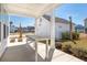 Covered back patio with wooden table, detached garage, and landscaped yard at 1445 Clay Field Trl, Summerville, SC 29485