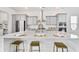 Kitchen island with white countertops, place settings, and gold barstools at 1445 Clay Field Trl, Summerville, SC 29485