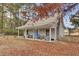 Quaint cottage with a covered porch, a bright blue door, and autumn leaves at 100 Sommet Blvd, Summerville, SC 29483