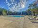 Community pool with lounge chairs, trees, and a sunny sky at 206 W Respite Ln, Summerville, SC 29483