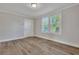 Living room with wood-look flooring, large windows, and neutral paint at 2675 Houston St, North Charleston, SC 29405