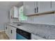 Updated kitchen boasts white shaker cabinets, granite counters, and stainless steel appliances at 2754 Houston St, North Charleston, SC 29405