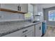 Remodeled kitchen features white shaker cabinets, granite counters, and a stylish blue dishwasher at 2754 Houston St, North Charleston, SC 29405