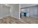 Living room with wood-look flooring, a doorway to a hallway, and a view of the kitchen at 2754 Houston St, North Charleston, SC 29405