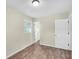 Empty bedroom with wood-look flooring, neutral walls, and access to another room at 3 Summit Ave, Goose Creek, SC 29445