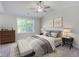 Main bedroom with a ceiling fan, windows, and a tufted bed with pillows and blankets at 518 Fleming Rd, Charleston, SC 29412