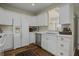 White kitchen with stainless steel appliances and hardwood floors at 56 Gibbes St # A, Charleston, SC 29401