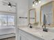 Modern bathroom with double vanity, white cabinets, and stylish wicker-framed mirrors at 587 Tribeca Ct, Charleston, SC 29414