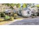 Exterior view of a home with a screened porch, landscaping, and a gravel driveway at 733 Fort Johnson Rd, Charleston, SC 29412