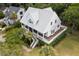 Bird's-eye view of a two-story house with a metal roof, deck, and green lawn at 1 Live Oak Dr, Isle of Palms, SC 29451