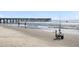 Beach scene with fishing equipment and pier in background at 1 Live Oak Dr, Isle of Palms, SC 29451