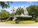 White two-story home with metal roof, porch, and lush landscaping at 1 Live Oak Dr, Isle of Palms, SC 29451