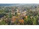 Aerial view of a home nestled in a wooded area with colorful autumn foliage at 1305 Sandy Run Cir, Summerville, SC 29486