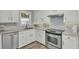 Modern kitchen with white cabinets, granite countertops, stainless steel appliances, and wood-look tile floors at 1481 Battery Reynolds Ct, Charleston, SC 29412