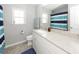 Bathroom with white vanity, granite countertop, and blue-striped shower curtain at 1526 Mcintosh Rd, Johns Island, SC 29455