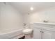 Clean and bright bathroom with white fixtures, a bathtub, and wood-style flooring at 1808 Calvert St, North Charleston, SC 29405