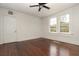 Sunlit bedroom with dark hardwood floors, white walls, and a ceiling fan at 1808 Calvert St, North Charleston, SC 29405