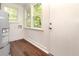 Laundry room with wood-look flooring, white wood paneling, and a door to the exterior at 1808 Calvert St # 123, North Charleston, SC 29405