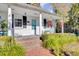 Quaint white cottage with a porch, brick walkway, and lush landscaping at 208 Sumter Ave, Summerville, SC 29483