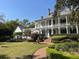 White two-story home with wrap-around porch, fountain, and manicured landscaping at 208 Sumter Ave, Summerville, SC 29483