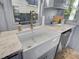 White farmhouse sink with marble countertop and gray cabinets at 208 Sumter Ave, Summerville, SC 29483