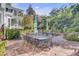 Brick patio with metal table and chairs, lush landscaping, and view of home at 208 Sumter Ave, Summerville, SC 29483