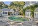Oval pool surrounded by a flagstone patio, lush landscaping, and pool house at 208 Sumter Ave, Summerville, SC 29483