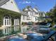 Curved pool, stone patio with lounge chairs, and lush landscaping at 208 Sumter Ave, Summerville, SC 29483