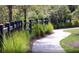 Landscaped walkway with a black fence and lush greenery at 749 Meadowbrook Ln, Summerville, SC 29486