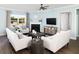 Cozy living room with fireplace, light colored sofas, and hardwood floors at 147 Royal Cainhoy Way, Huger, SC 29450