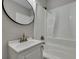 Clean bathroom with white tub/shower, vanity, and round mirror at 2265 Bailey Dr, North Charleston, SC 29405