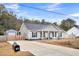 Gray house with rocking chairs on the front porch and a long driveway at 255 S Railroad Avenue, Ridgeville, SC 29472