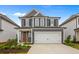 Two-story gray house with white garage door and landscaping at 318 Abercom Place Dr, Moncks Corner, SC 29461
