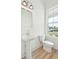 Clean bathroom with pedestal sink, toilet, and a window with a neighborhood view at 825 Gentle Breeze Dr, Summerville, SC 29486