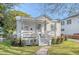 White cottage with a metal roof, front porch, and nicely landscaped yard at 1328 Cottonwood St, Charleston, SC 29403