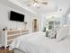 Bright bedroom with white furniture, large TV, and hardwood floors at 172 Sea Cotton Cir, Charleston, SC 29412