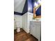 Stylish bathroom with white vanity, dark blue walls, and wood floor at 1738 Trewin Ct, Charleston, SC 29492