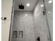 Large walk-in shower with marble-look tiles and built-in shelving at 42 Summer Dr, Walterboro, SC 29488