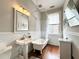 Elegant bathroom with clawfoot tub, white pedestal sink and wood floors at 12 John St # Includes 8 & 10, Charleston, SC 29403