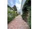 Brick pathway lined with lush greenery, leading to the back of the property at 12 John St # Includes 8 & 10, Charleston, SC 29403
