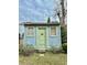 Light blue storage shed with green door, two windows, and stone steps at 12 John St # Includes 8 & 10, Charleston, SC 29403