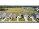 Aerial view of homes with a pond and open field in the background at 120 Clear Tide Dr, Summerville, SC 29486