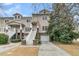 Tan three-story home with white stairs, attached garage, and landscaping at 121 Etiwan Pointe Dr, Mount Pleasant, SC 29464