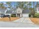 Two-story house with a gray roof, beige siding, and a white garage door at 141 Penzance Blvd, Goose Creek, SC 29445