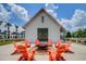 Relaxing fire pit area with orange chairs and a white barn backdrop at 144 Clear Bend Ln, Summerville, SC 29486