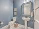 Stylish powder room with pedestal sink, blue walls, and modern fixtures at 1935 Chestnut Oak Ln, Charleston, SC 29414